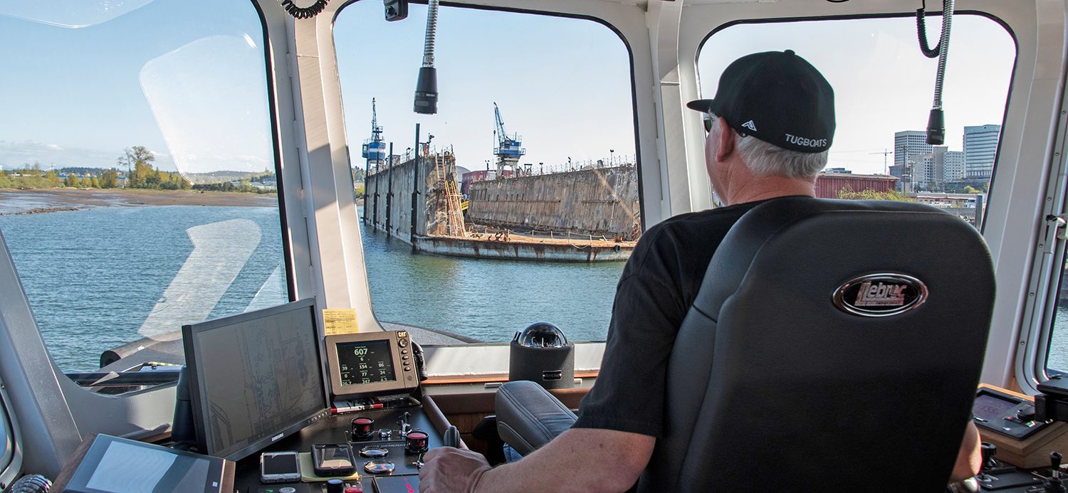 Wheelhouse view of a tug captain maneuvering in harbor during hands-on Z-drive tractor tug handling training at MITAGS-West.